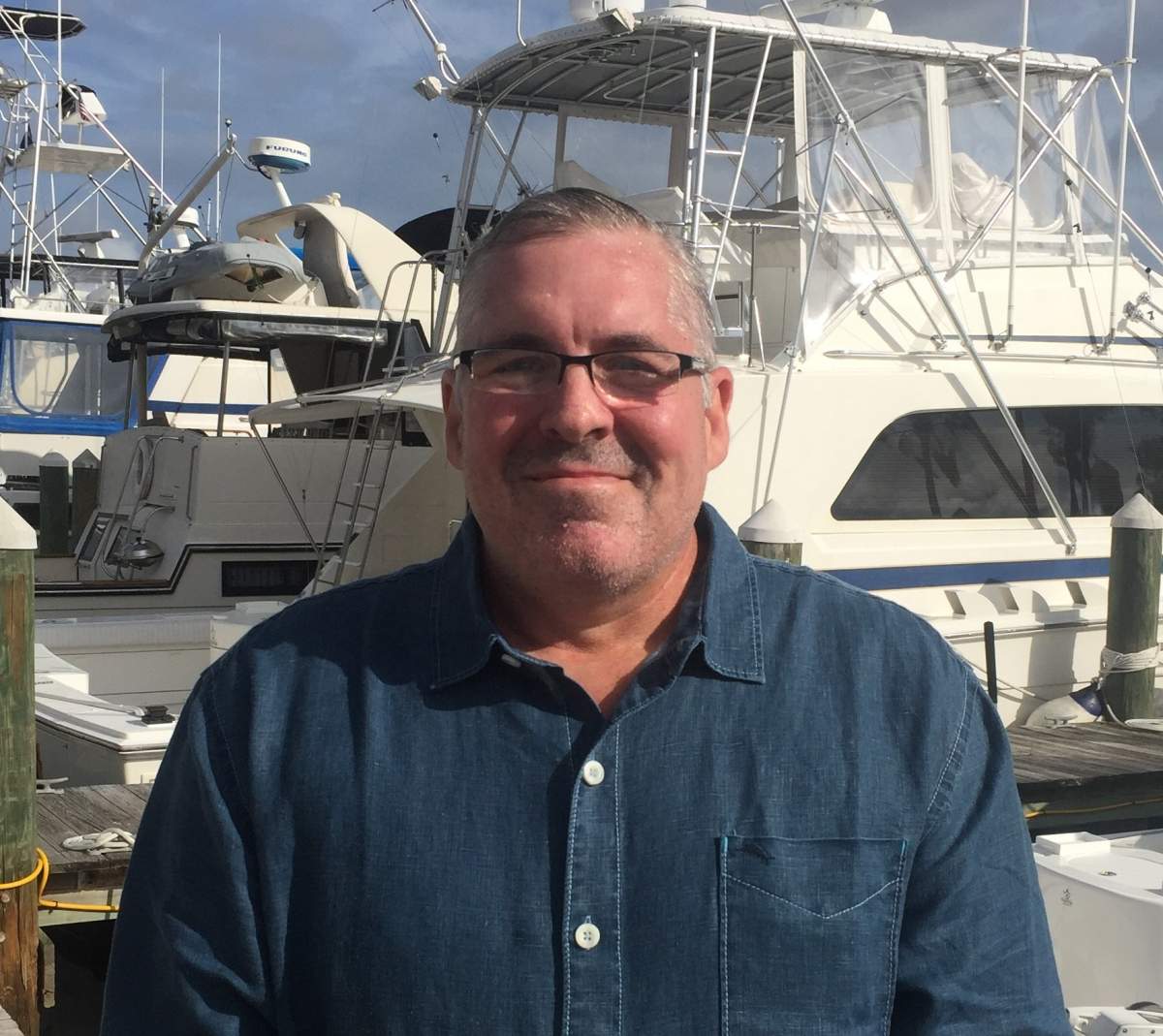 Gerald L. Kraaz standing in front of a boat