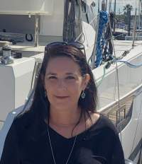 Julie Gaines standing next to a boat