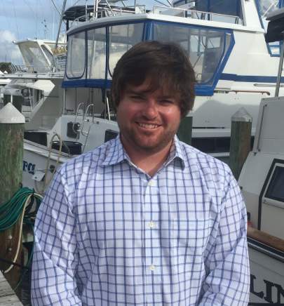 Taylor Beckford smiling and standing in front of boats